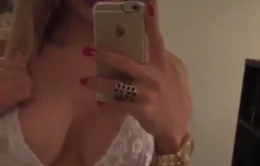 Loira cavalona de lingerie transparente se exibindo no espelho até gozar