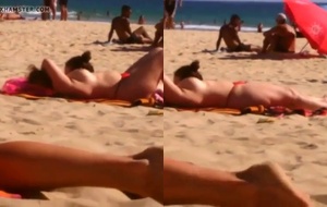 Coroa safada exibindo os peitos na praia cheia e sendo filmada por um tarado