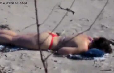 Esposa safada de fio dental provocando na praia para o marido corno
