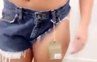 Novinha exibindo a bunda no provador com shortinho rasgado